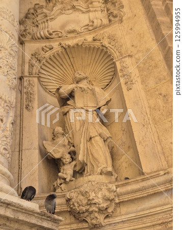 Ancient sculptures of Christian saints on the walls of a Spanish catholic temple 125994955