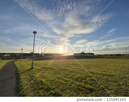 Sunrise over Agricultural Landscape with Grass and Clouds Sunrise over Agricultural Landscape with Grass and Clouds 125995165