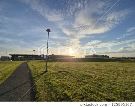Dusk Sky with Clouds Over Grassy Land Lot Dusk Sky with Clouds Over Grassy Land Lot 125995167