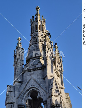City Tower with Turret and Spire Against Blue Sky 125995179