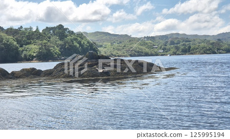 Scenic Highland Lake Surrounded by Mountains and Trees 125995194