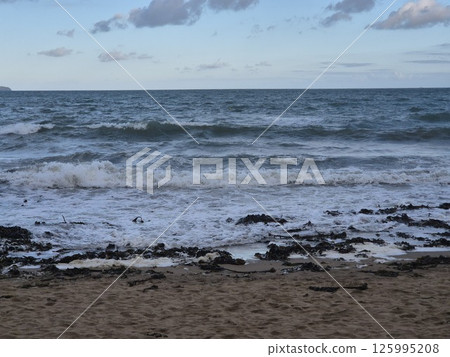 Coastal Beach Under Azure Sky with Clouds and Water 125995208
