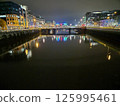 Cityscape at Dusk with Bridge Over Lake and Reflections in Water 125995461