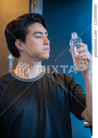 日本男子在健身房裡嘴裡含著水 125995600