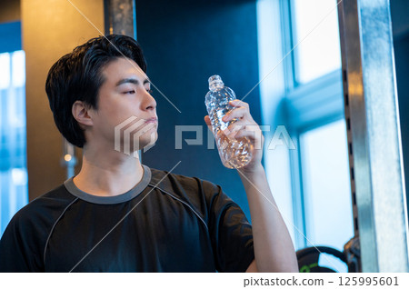Japanese man holding water in his mouth at the gym 125995601