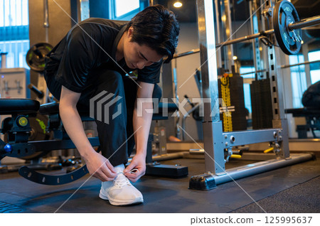Japanese man putting on shoes at the gym 125995637