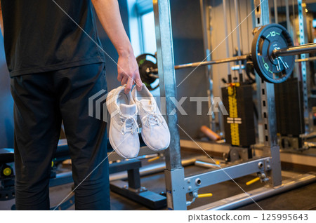 Japanese man holding shoes at gym 125995643