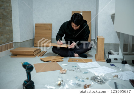 Japanese man assembling furniture 125995687
