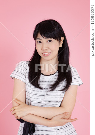 A woman smiling with her arms A woman smiling with her arms 125996573