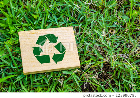 Top view of close up Recycle symbol on wooden block with customizable space for text. For a greener tomorrow concept 125996783