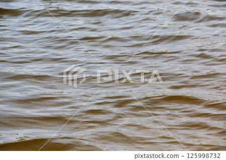 Background of Dnieper River water surface with ripples. Natural color of river water. Background of Dnieper River water surface with ripples. Natural color of river water. 125998732
