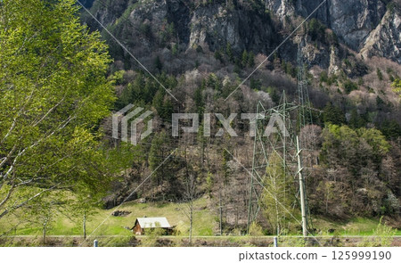 A little old wood house between mountains with much trees. Nature background with Alps in Switzerland, Europe. 125999190