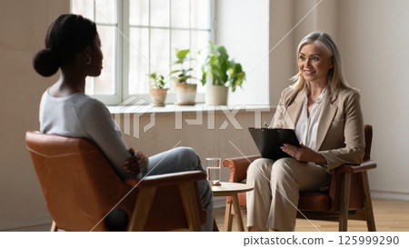 Black Woman in Therapy, Calm Counseling Session with Warm Lighting and Serene Ambience Black Woman in Therapy, Calm Counseling Session with Warm Lighting and Serene Ambience 125999290