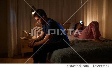 Man Alone on Bed While Woman Scrolls Phone, Emotional Neglect Scene 125999337