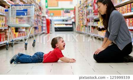 Toddler Having Meltdown in Grocery Store Aisle While Parent Stays Calm 125999339