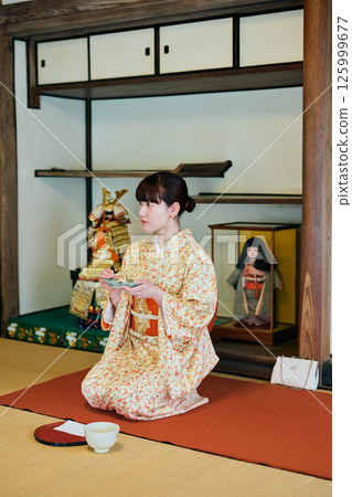 A woman in her twenties wearing a kimono experiencing a tea ceremony A woman in her twenties wearing a kimono experiencing a tea ceremony 125999677