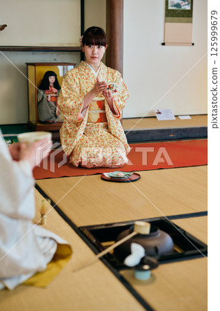 A woman in her twenties wearing a kimono experiencing a tea ceremony A woman in her twenties wearing a kimono experiencing a tea ceremony 125999679