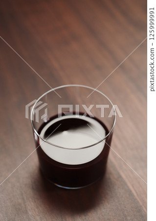 Red wine in tumbler glass on a walnut table with copy space Red wine in tumbler glass on a walnut table with copy space 125999991