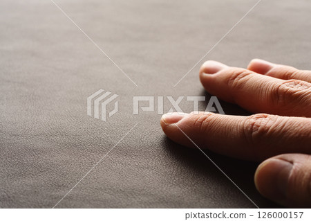 Closeup man hand check dark brown full grain leather 126000157