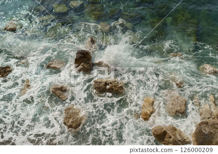 Top down view of sea waves crushing onto rocks Top down view of sea waves crushing onto rocks 126000209