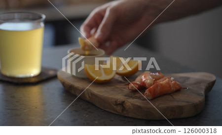 Man dip crab leg into pesto sauce with ginger beer on background 126000318