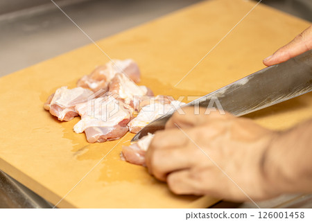 Chicken thighs are being cooked on a synthetic rubber cutting board Chicken thighs are being cooked on a synthetic rubber cutting board 126001458