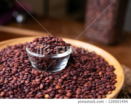 Organic uncooked seeds dark red brown lentils. 126001494