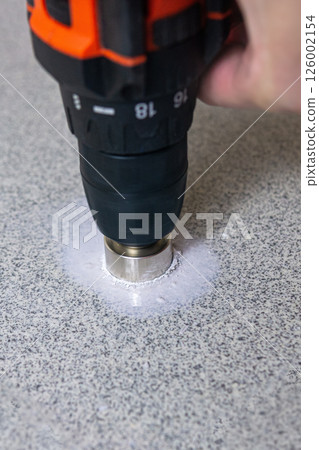 rotating diamond core hole saw drilling into a stone slab rotating diamond core hole saw drilling into a stone slab 126002154