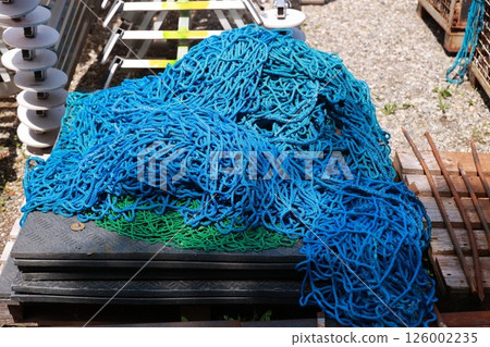 A pile of blue and green fishing netting 126002235