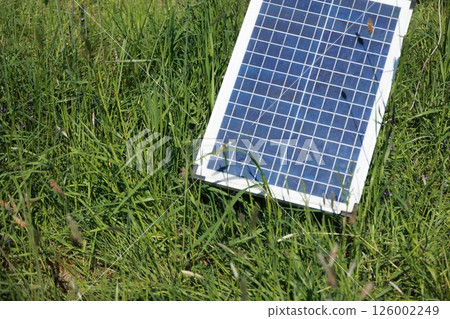 A solar panel is laying on the grass 126002249
