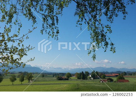 A beautiful countryside scene with a blue sky and mountains in the background A beautiful countryside scene with a blue sky and mountains in the background 126002253