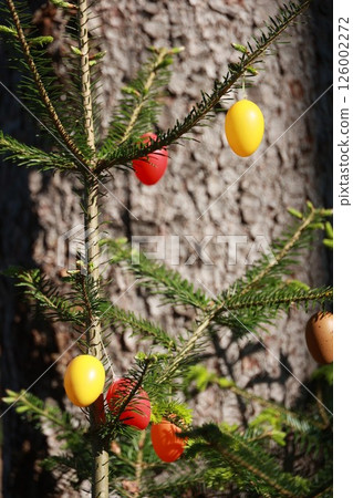 A tree with eggs hanging from its branches 126002272