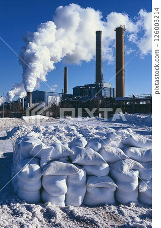 Industrial landscape with coal plant and snow-covered sandbags under clear blue sky Industrial landscape with coal plant and snow-covered sandbags under clear blue sky 126003214