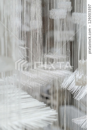 Abstract modern installation with intricate white threads: minimalist design and ethereal atmosphere for contemporary spaces Abstract modern installation with intricate white threads: minimalist design and ethereal atmosphere for contemporary spaces 126003897