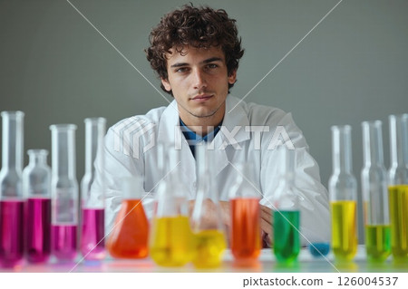 Curious scientist amidst colorful laboratory glassware in research lab setting 126004537