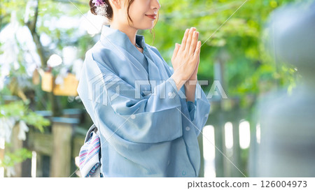 A woman in a yukata worshiping at a shrine A woman in a yukata worshiping at a shrine 126004973