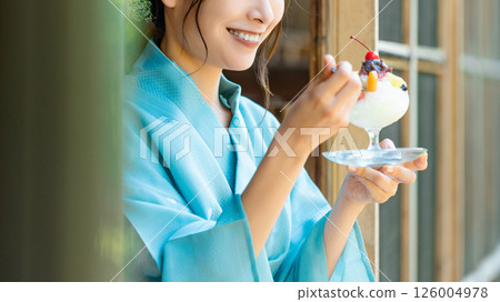 A Japanese woman in a yukata eating shaved ice on the veranda A Japanese woman in a yukata eating shaved ice on the veranda 126004978