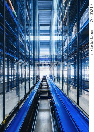 Modern industrial warehouse interior with automated storage system and vibrant blue pallets in a futuristic logistics setting 126005219