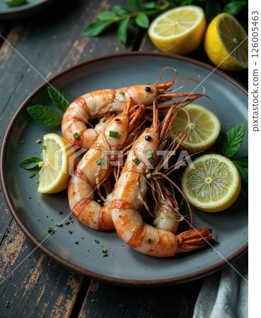 Gourmet seafood delight: grilled shrimp with fresh lemons on rustic plate 126005463