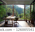 Modern Home Office Interior with Natural Light and Large Glass Windows Overlooking Lush Green Forest, Minimalist Workspace Design with Wooden Desk, Indoor Plants, and Serene Eco Friendly Atmosphere 126005541