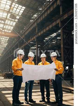Industrial architecture team reviewing blueprints in expansive warehouse setting for strategic planning and project management Industrial architecture team reviewing blueprints in expansive warehouse setting for strategic planning and project management 126005586