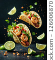 Vibrant shrimp taco explosion with fresh lime and cilantro on black background - perfect for culinary blogs and mexican cuisine lovers 126006870