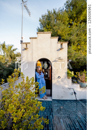 Woman relaxing at rustic rooftop shower entry in Mediterranean home Woman relaxing at rustic rooftop shower entry in Mediterranean home 126006961
