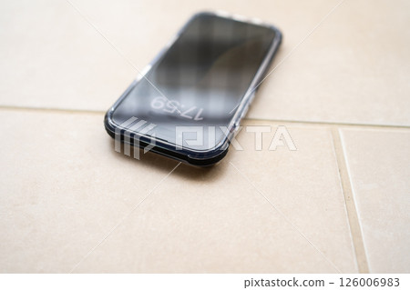 Smartphone in shockproof silicone case on tiled floor after falling. 126006983