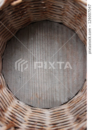 A look inside a homecraft wicker basket with a wooden bottom. Bottom of vintage handicraft  braided basket made of wicker and wood 126007047