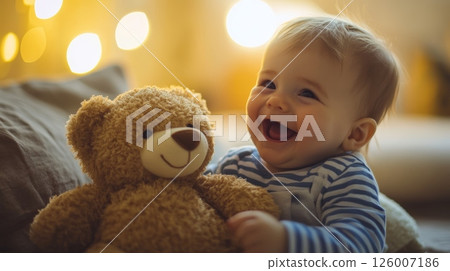 A cheerful baby with a teddy bear, surrounded by warm lights, creating a cozy atmosphere 126007186