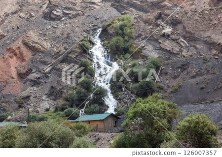 Dramatic waterfall cascades down rocky mountain side in Tajikistan Dramatic waterfall cascades down rocky mountain side in Tajikistan 126007357