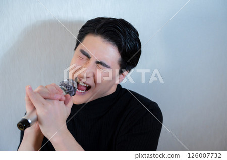 日本男子對著麥克風熱情地唱歌 日本男子對著麥克風熱情地唱歌 126007732