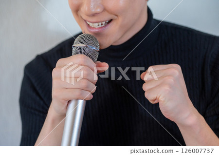 Japanese man singing enthusiastically into a microphone Japanese man singing enthusiastically into a microphone 126007737