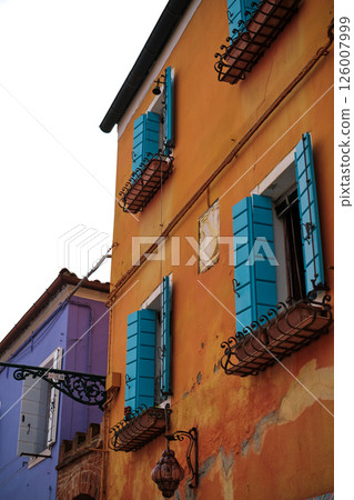 Colourful houses on the island of Burano, Italy, known for its brightly coloured facades and charming canals. Brightly coloured buildings line the narrow streets and waterways, horizontal photo Colourful houses on the island of Burano, Italy, known for its brightly coloured facades and charming canals. Brightly coloured buildings line the narrow streets and waterways, horizontal photo 126007999
